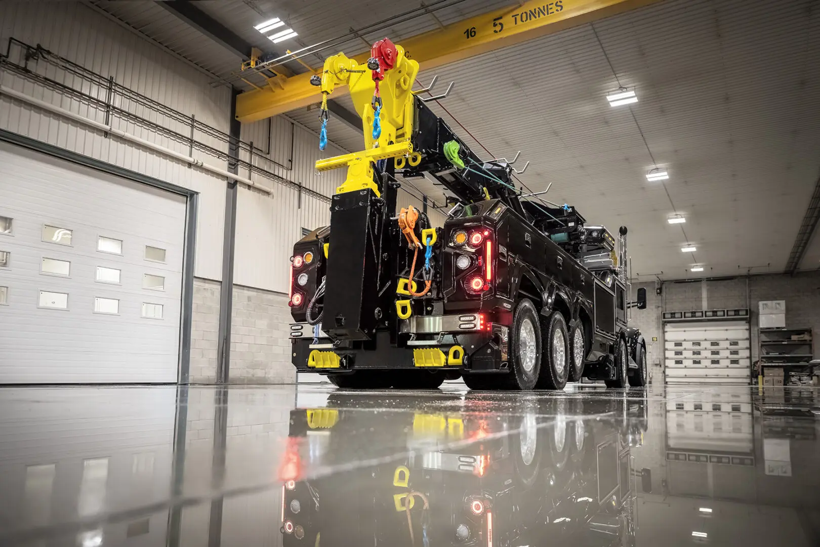 Heavy-duty tow truck inside industrial garage.