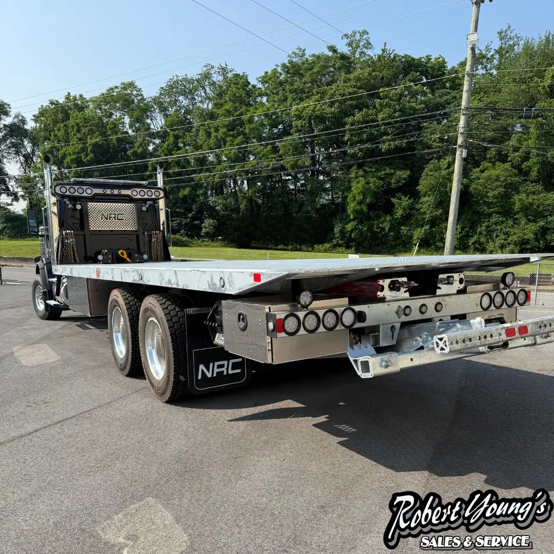 Flatbed truck parked on asphalt road.