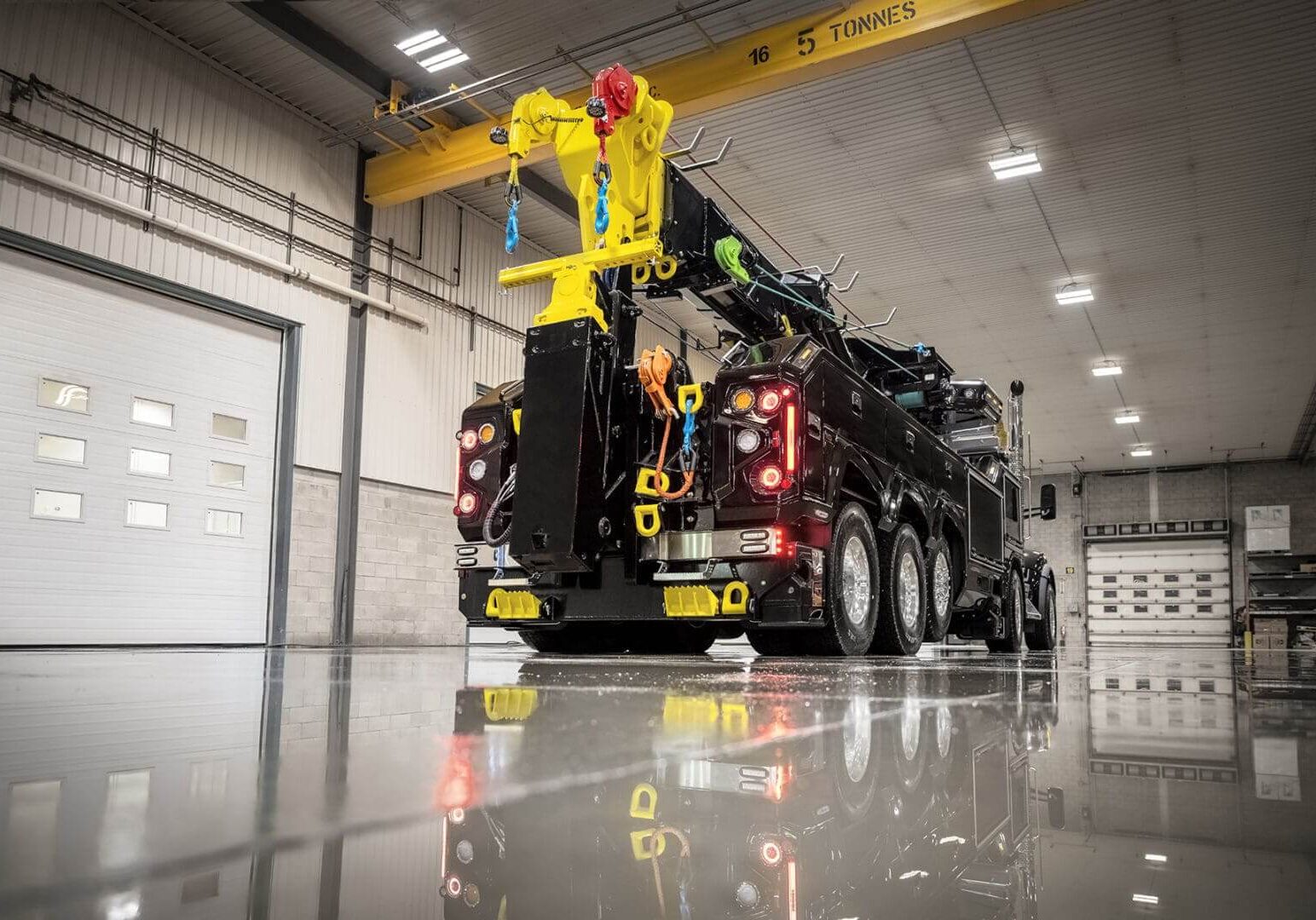 Heavy-duty tow truck inside industrial garage.
